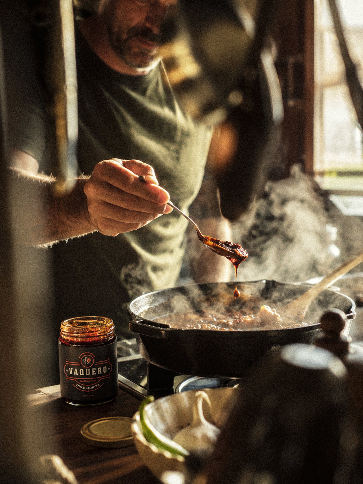 Cook adding Vaquero to a steaming pan
